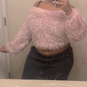 A pink fluffy off the shoulder sweater